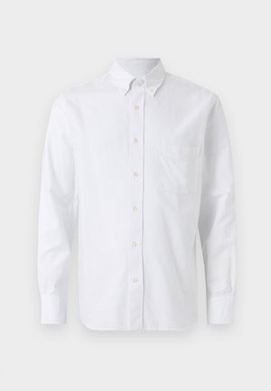 Chemise blanche à manches longues avec boutons sur le devant, col à boutons, et une poche poitrine, présentée sur un fond uni.