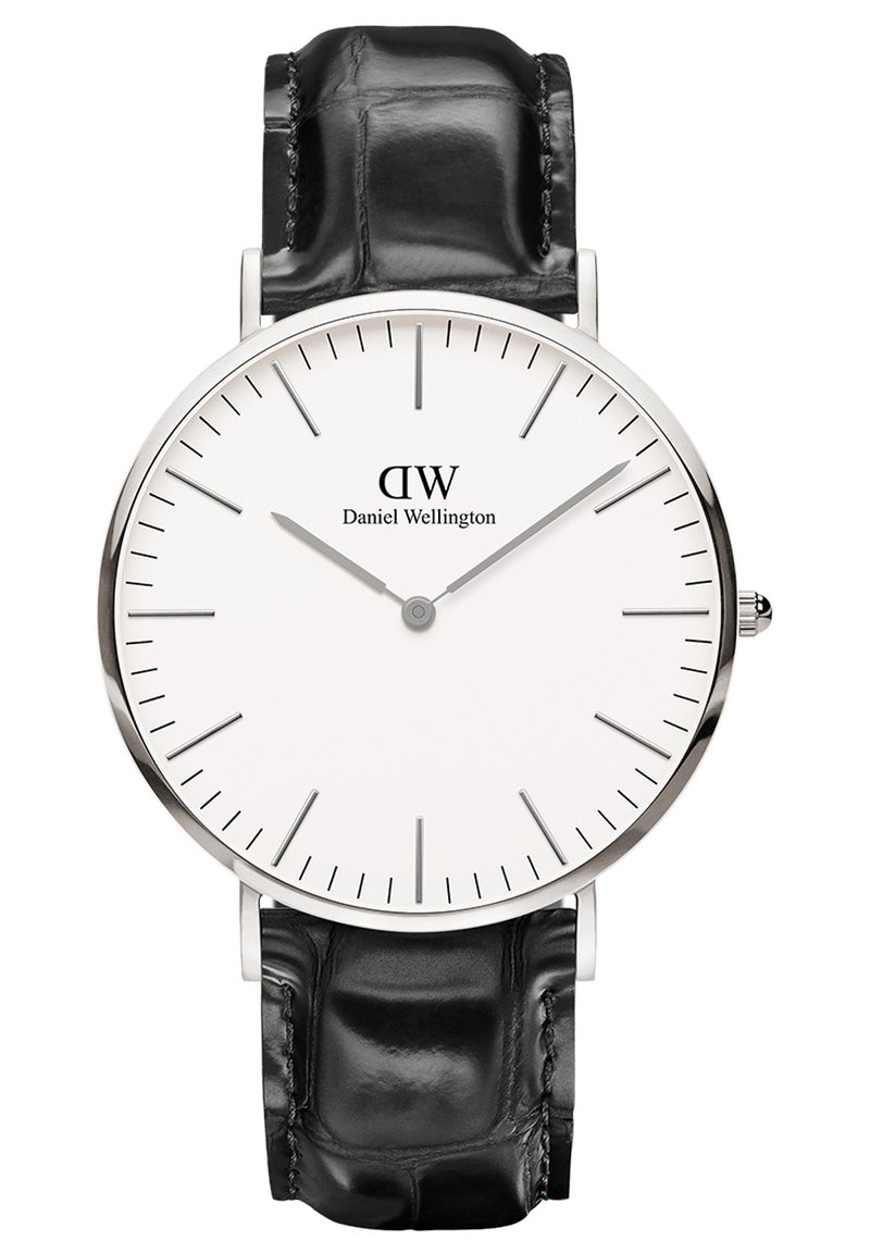Orologio con quadrante bianco rotondo e indicatori delle ore argentati, con il nome del marchio "Daniel Wellington", e un cinturino in pelle di coccodrillo nera.