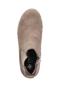 Botín de ante beige con puntera redondeada, paneles laterales elásticos y un zip con acento metálico. Forro interior suave con el logo visible.