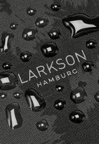 Zwarte geweven stof met waterdruppels. Bevat het logo "LARKSON HAMBURG" in het wit. Reflecterende druppels verhogen de visuele details.