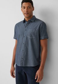 Korte mouwen, knoopsluiting shirt in donkerblauw denim, voorzien van een borstzak en contrasterende witte stiksel langs de kraag en mouwen.