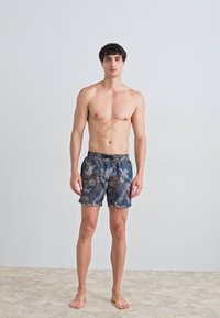 Pantaloni scurți de înot de culoare bleu închis, cu un model floral tropical. Material ușor, talie elastică și închidere cu șnur.
