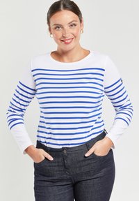 Hemd met lange mouwen in blauw en witte horizontale strepen, ronde halslijn en zachte stof. Draagt met donkere spijkerbroek.