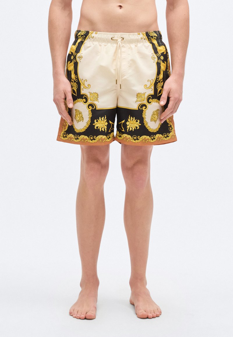 Μαγιό σορτς με ελαστική μέση, σε αποχρώσεις μπεζ  και μαύρου, με χρυσαφένια διακοσμητικά σχέδια και δύο πλαϊνές τσέπες.