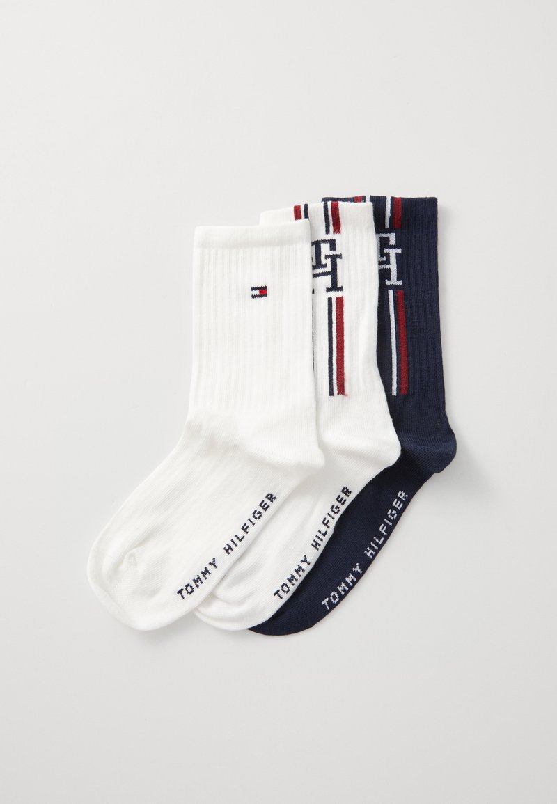 Trzy pary bawełnianych skarpetek w kolorach białym, granatowym i mieszanym. Białe skarpetki mają ryps i małe logo, natomiast granatowa para jest w paski.