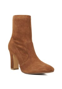 Suède enkellaars in bruin met een spitse neus en een stilettohak. Heeft naadloze zijkanten en een gladde, matte textuur.