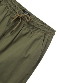 Bermuda verde oliva realizzate in tessuto leggero, con vita elastica e coulisse, e tasche laterali. Design semplice e pratico.