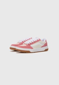 Pink and white athletic shoes with suede and mesh materials, featuring round laces, a textured gum sole, and perforated detailing on the side.