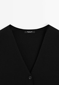 Zwarte geribde cardigan met een V-hals ontwerp. Bevat een enkele zwarte knoopsluiting en een label met de tekst "Massimo Dutti."