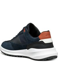 Sneaker en suède marine avec un panneau en cuir noir, une semelle intermédiaire blanche et un accent orange au talon. Semelle extérieure en caoutchouc texturé pour une meilleure adhérence.