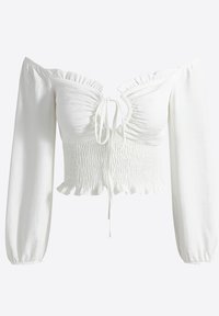 White off-shoulder crop top with long puff sleeves, smocked bodice, ruffled neckline, and adjustable tie at the front. Smooth fabric texture.