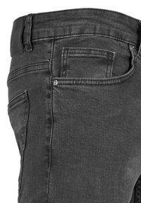 Črne jeans hlače slim fit kroja, z enim sprednjim žepom in majhnim žepom za kovance. Tkanina ima rahlo elastičnost in je v bledem videzu.