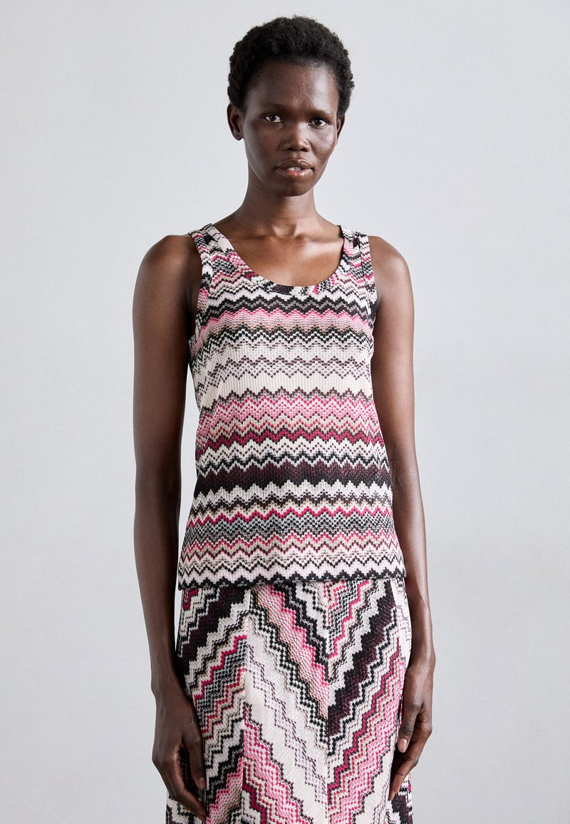 Top in maglia con motivo zigzag multicolore in rosa, nero e crema, caratterizzato da un collo a giro e una silhouette aderente.