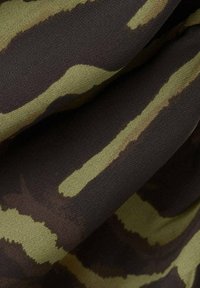 Tkanina z wzorem kamuflażu z ciemnobrązowymi i oliwkowozielonymi paskami na teksturowanym tle tkaniny. Gładkie wykończenie powierzchni.