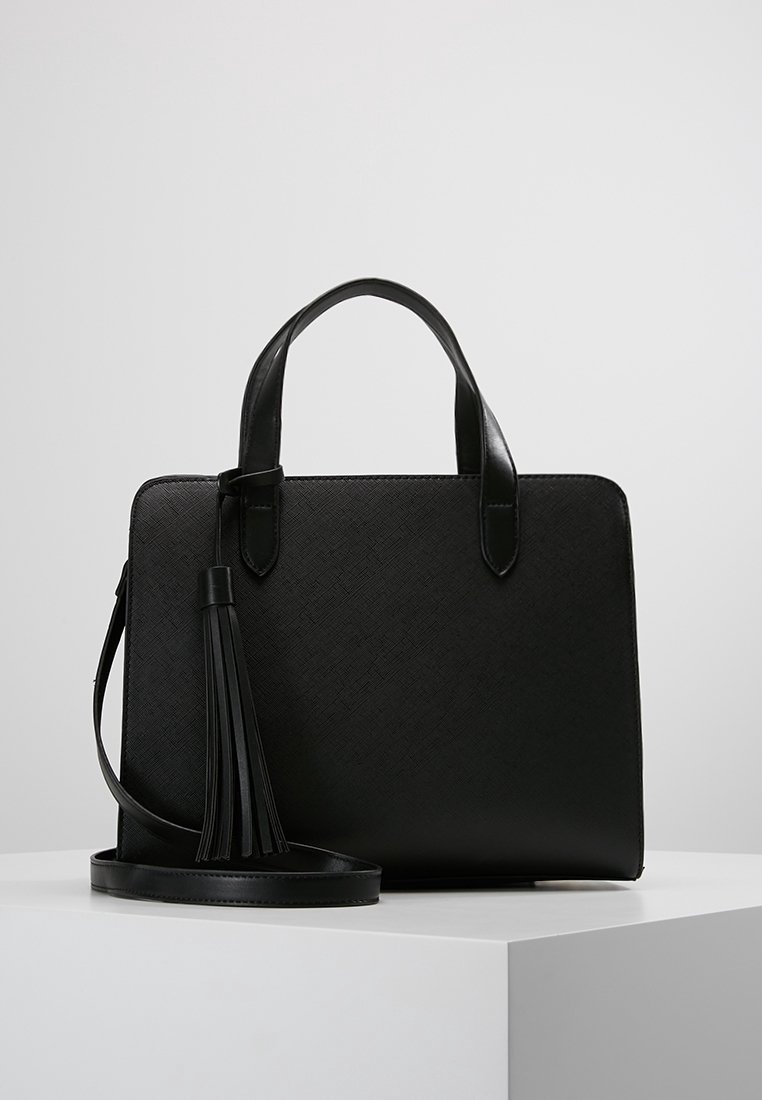 Borsa nera dal design strutturato. Realizzata in materiale testurizzato, dotata di manici corti e tracolla staccabile con un dettaglio a nappina.