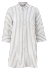 Camicia bianca con sottili righe beige, maniche a 3/4 e colletto a punte. Presenta una silhouette dritta e spacco laterale all'orlo.