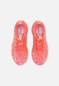 Helle korallenfarbene Sportschuhe mit einem strukturierten Mesh-Obermaterial, flachen Schnürsenkeln, verstärkten Fersenlaschen und dezenten weißen Akzenten.