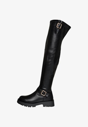 Zwarte leren kniehoge laars met een dikke zool en twee gouden gespstraps, één bij de enkels en één aan de bovenkant.