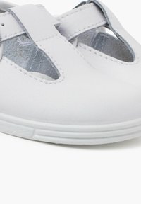 Scarpe bianche in pelle con design a fori e morbida consistenza. Presentano una punta arrotondata e una fodera interna grigia. Suola in gomma bianca flessibile.