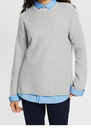 Pull en maille texturée grise avec un col rond, doté d'une chemise bleu sous-jacente et de poignets côtelés. Design à coupe décontractée.