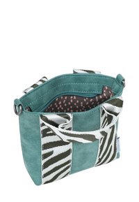 Teal suède tas met zebra-patroon stofaccenten, zilveren hardware en eenvoering met stippen. Voorzien van twee stevige handvaten en een ritsvak.