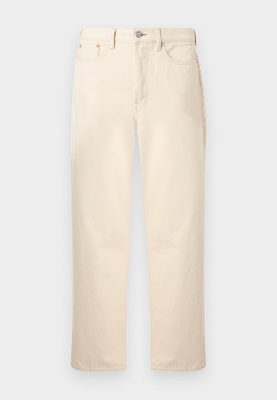Μπεζ τζιν με ίσια γραμμή στο πόδι, πέντε τσέπες, κούμπωμα με κουμπί, θηλιές για ζώνη και φερμουάρ.
