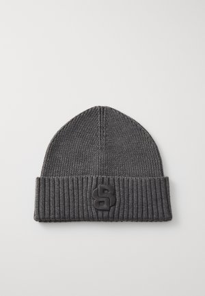 Dark gray knitted beanie with a ribbed cuff and a distinct black logo patch on the front, featuring a rounded shape and smooth texture.