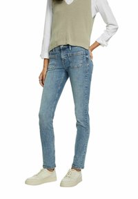 Ljust blå denimjeans med slim fit. Har fram- och bakfickor samt en klassisk femficksdesign. Kombinerat med krämfärgade sneakers.