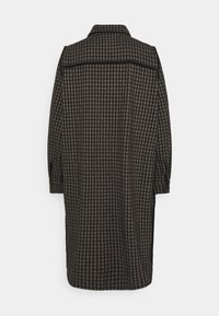 Rutigt mörkt kappa med avslappnad passform, med krage och uppvikta 3/4-ärmar, tillverkad av ett strukturerat tyg.