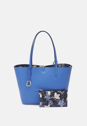 Sac cabas en cuir bleu avec longues anses, détail boucle dorée et pochette zippée assortie à motif floral dans des tons marine et crème.
