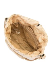 Intérieur d'un sac à main beige avec une doublure en tissu lisse portant un texte répétitif "WITTCHEN". Comprend une poche zippée et un espace généreux.