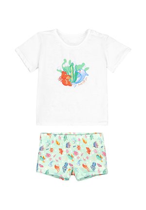Camiseta blanca de manga corta con diseño de pez y delfín, combinada con pantalones cortos verde claro con un patrón de coloridas criaturas marinas y plantas.
