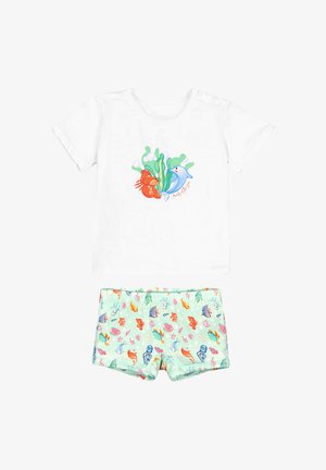 Camiseta blanca de manga corta con diseño de pez y delfín, combinada con pantalones cortos verde claro con un patrón de coloridas criaturas marinas y plantas.
