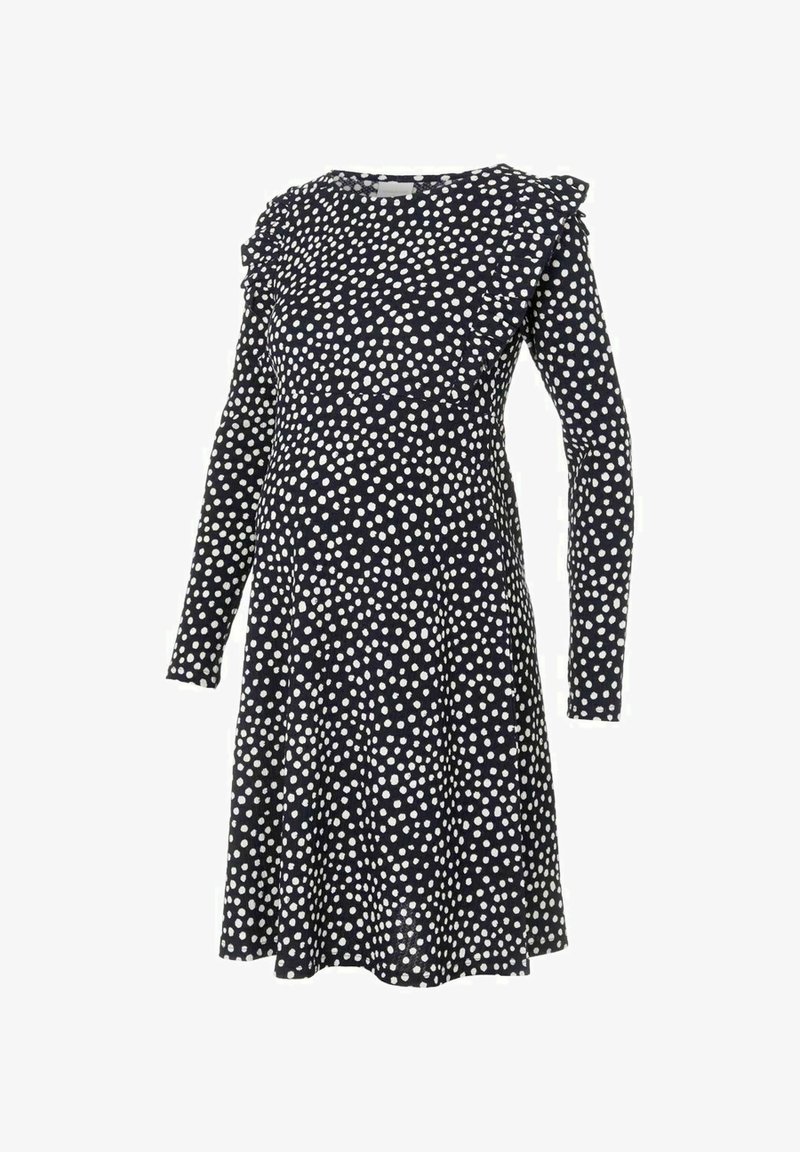 Robe noire à manches longues avec des pois blancs irréguliers, épaules à volants et jupe évasée.