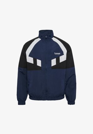 Granatowa kurtka sportowa z czarno-białymi akcentami geometrycznymi, z pełnym zamkiem, stójką, elastycznymi mankietami oraz logotypem na lewej piersi.