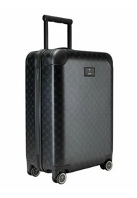 Valigia rigida nera con motivo testurizzato, dotata di manico telescopico, ruote fluide e una targhetta con logo sul davanti.