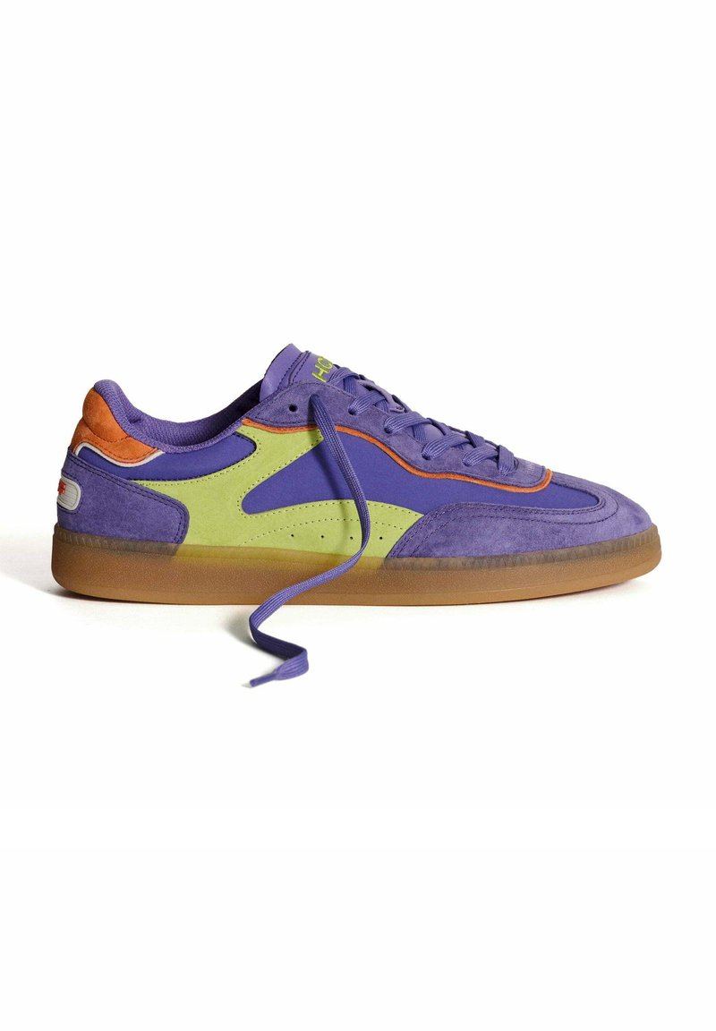Zapatilla púrpura con acentos en verde y naranja, materiales de ante y sintéticos, suela de goma, cordones planos y diseño de puntera redonda.