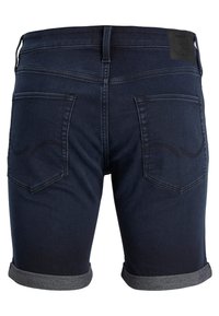 Shorts de mezclilla oscura con dobladillo enrollado, que cuentan con bolsillos traseros y un parche de marca de cuero en la cinturilla. Textura suave y diseño ajustado.
