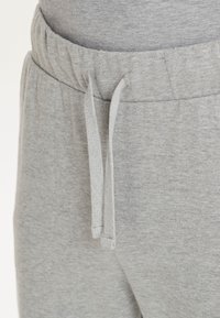 Graue Sweatpants mit einem elastischen Bund, Kordelzugverschluss und einem weichen, strukturierten Stoff. Das Design verfügt über flache Nähte und keine Taschen.
