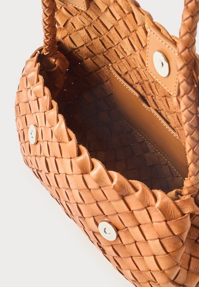 Καφέ υφαντή δερμάτινη τσάντα χειρός με πλεγμένες λαβές, κλείσιμο με μαγνητικό κουμπί και εσωτερική τσέπη από λείο δέρμα.