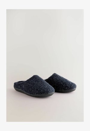Dunkelblaue, flauschige Hausschuhe mit einer strukturierten Oberseite, geschlossenem Fersenbereich und einer robusten schwarzen Gummisohle. Weiches Material für zusätzlichen Komfort.