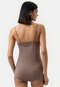 Bruine cami met kantafwerking aan de bovenkant, dunne verstelbare bandjes en een aansluitend ontwerp. Zachte textuur, doorgaans gedragen als slaapkleding of loungewear.