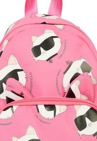 Zaino rosa con un design di un gatto con occhiali da sole, realizzato in materiale flessibile, decorato con illustrazioni in stile cartone animato e una cerniera frontale.