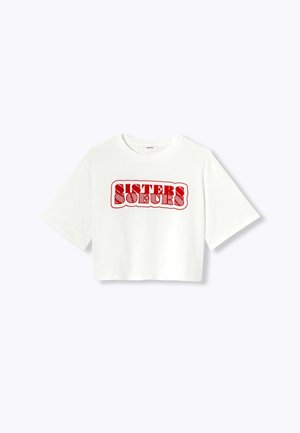 T-shirt blanc court présentant un graphique rouge audacieux avec le texte "SISTERS" dans une police ondulée. Manches courtes et coupe décontractée.