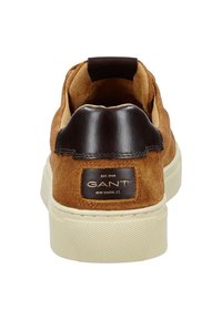 Hnědé semišové tenisky s tmavohnědým koženým patním tabu a krémovou pryžovou podrážkou, se znakem značky GANT na zadní straně.