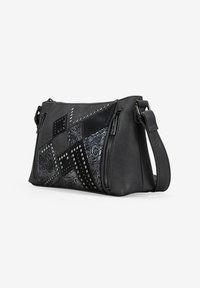 Bolso de mano negro hecho de cuero sintético texturizado con acentos de tachuelas, diseño de patchwork geométrico y compartimentos con cremallera.
