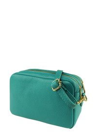 Turquoise leren crossbodytas met gouden accenten, rechthoekige vorm, twee ritssluitingen en een gestructureerd oppervlak. Verstelbare band inbegrepen.