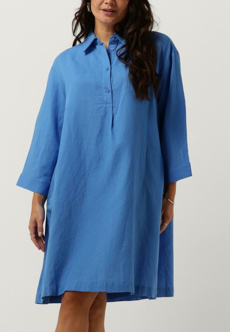 Blå lin skjortekjole med kragehals, knappestolpe, lange ermer og lommer. Kneelengde med avslappet passform og jevn tekstur.