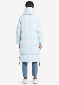 Ljusblå puffjacka med hög krage, oversized passform och geometrisk quiltning. Har sidofickor och justerbar dragsko i nederkant.