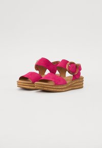 Fuchsia suède wedge sandalen met brede kruislijndecoratie, ronde hardware accent en een gestructureerde kurken zool met gelaagde ribbels.